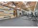 Spacious gym featuring exposed wood ceiling, ample equipment, large mirrors and a reclaimed wood accent wall at 110 White Oak Trl, Cumming, GA 30028