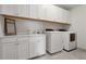 Bright laundry room equipped with modern washer and dryer, ample cabinet space, and a sink at 110 White Oak Trl, Cumming, GA 30028