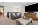 Upstairs loft area featuring comfortable sofas, an ottoman, and mounted TV at 110 White Oak Trl, Cumming, GA 30028