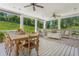 Covered back porch featuring a dining table, seating area, and ceiling fans, ideal for outdoor living at 110 White Oak Trl, Cumming, GA 30028