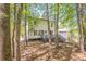 View of the backyard and back exterior of the home through mature trees at 1331 Windage Sw Ct, Marietta, GA 30008