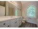Bathroom featuring a white vanity, arched window and wood-look floors with neutral toned walls at 1331 Windage Sw Ct, Marietta, GA 30008