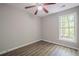 Bright bedroom features wood-look flooring and a ceiling fan with a wooded view from a large window at 1331 Windage Sw Ct, Marietta, GA 30008