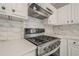 Stylish kitchen with stainless steel stove, modern range hood, white quartz countertops, and ample cabinet space at 1331 Windage Sw Ct, Marietta, GA 30008