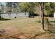 Home with a spacious backyard, featuring a partial fence and mature trees in the background at 153 Helen Rd, Covington, GA 30016