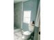 Bright bathroom boasts a tiled shower, a toilet, and a window allowing natural light to fill the space at 153 Helen Rd, Covington, GA 30016