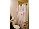 Functional bathroom featuring a toilet and shower with a decorative floral-patterned curtain at 153 Helen Rd, Covington, GA 30016
