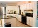 Kitchen featuring white cabinets, black appliances, and granite countertops at 153 Helen Rd, Covington, GA 30016