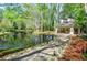 Scenic pond view with a charming gazebo, lush landscaping, and mature trees at 407 Coleraine Se, Smyrna, GA 30080