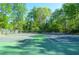 Outdoor tennis courts surrounded by mature trees with lights for evening play at 407 Coleraine Se, Smyrna, GA 30080