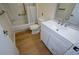 This well lit bathroom includes updated vanity with white cabinets, brushed nickel fixtures and hardwood flooring at 475 Mount Vernon Ne Hwy # C-220, Sandy Springs, GA 30328