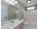 Well-lit bathroom with a combination tub and shower, a large mirror, and a sink with vanity at 1234 W Wylie Bridge Rd, Woodstock, GA 30188