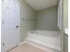 Relaxing bathroom featuring a soaking tub, storage shelves, and natural light at 1234 W Wylie Bridge Rd, Woodstock, GA 30188