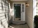 Exterior close-up of front door and entryway, featuring a light fixture and stone step at 1234 W Wylie Bridge Rd, Woodstock, GA 30188