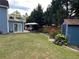 Green backyard featuring a large storage shed, outdoor seating under an umbrella, and lush green lawn at 3147 Pine Needle Sw Ct, Lilburn, GA 30047