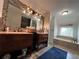 Bright bathroom featuring a double vanity, large mirror, a soaking tub, and a blue rug at 3147 Pine Needle Sw Ct, Lilburn, GA 30047