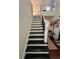 View of the staircase featuring black wooden stairs and a black iron handrail at 3147 Pine Needle Sw Ct, Lilburn, GA 30047