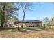 Backyard features mature trees, brick home exterior and new wooden deck at 8298 Holly Dr, Jonesboro, GA 30238