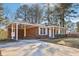 Side view of a brick home with a covered carport and manicured landscaping at 8298 Holly Dr, Jonesboro, GA 30238