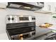 Stainless steel range with sleek black stovetop and modern vent hood in updated kitchen at 8298 Holly Dr, Jonesboro, GA 30238