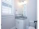 Well-lit half bathroom with a window, granite countertop, and a pristine white toilet at 925 Sunny Meadows Ln, Marietta, GA 30062