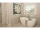 Modern bathroom featuring a standalone bathtub, complemented by large floral art and natural light at 925 Sunny Meadows Ln, Marietta, GA 30062