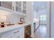Stylish butler's pantry with glass cabinets, wine fridge, and subway tile backsplash, perfect for entertaining at 925 Sunny Meadows Ln, Marietta, GA 30062