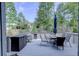 Back deck featuring outdoor seating, grill, and storage box, surrounded by lush trees at 925 Sunny Meadows Ln, Marietta, GA 30062