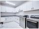 Well-lit laundry room with white cabinetry, granite countertops, stainless steel appliances, and tile floors at 925 Sunny Meadows Ln, Marietta, GA 30062