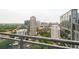 Balcony view of city skyline with surrounding buildings, lush greenery, and street views at 1065 Peachtree Ne St # 2803, Atlanta, GA 30309