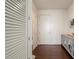 Hallway featuring wood floors, white doors, closet with louvered doors, and a decorative cabinet at 1065 Peachtree Ne St # 2803, Atlanta, GA 30309
