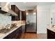 Open kitchen with stainless steel fridge, gas range, and dark wood cabinetry at 1065 Peachtree Ne St # 2803, Atlanta, GA 30309