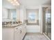 Bright bathroom with double vanity, granite countertop, a tub, and glass shower at 4568 Mantova Dr, Buford, GA 30519