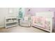 Charming Bedroom with crib, changing table, and cozy seating area at 4568 Mantova Dr, Buford, GA 30519
