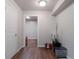 Hallway featuring wood floors, white trim, a door and an open view into another room at 4568 Mantova Dr, Buford, GA 30519