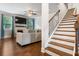 Bright living room with a ceiling fan, fireplace, hardwood floors, and stairs to the second floor at 4568 Mantova Dr, Buford, GA 30519