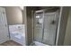 Bathroom featuring a separate tub and glass shower with tile surround at 1015 Pebble Creek Trl, Suwanee, GA 30024