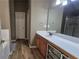 Bathroom with wood floor, cabinet storage, and large mirror at 1015 Pebble Creek Trl, Suwanee, GA 30024