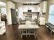 Bright kitchen features an island, stainless appliances, granite countertops, and a dining area at 1015 Pebble Creek Trl, Suwanee, GA 30024