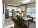 Open kitchen features an island, stainless appliances, granite countertops, and a dining area at 1015 Pebble Creek Trl, Suwanee, GA 30024