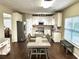 Bright kitchen features an island, stainless appliances, granite countertops, and a dining area at 1015 Pebble Creek Trl, Suwanee, GA 30024