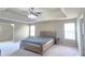 Spacious main bedroom featuring a large window, tray ceiling, and ceiling fan at 1015 Pebble Creek Trl, Suwanee, GA 30024