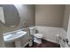 A well-lit powder room with a pedestal sink, toilet, and neutral-colored walls at 1015 Pebble Creek Trl, Suwanee, GA 30024