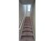 Carpeted stairway with handrail leads to upper level of home; natural light from window at 1015 Pebble Creek Trl, Suwanee, GA 30024