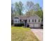 Charming split-level home with grey siding, well-maintained lawn and two-car garage at 1084 Whistle Dr, Austell, GA 30106