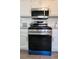 Close up of stainless steel gas range and microwave with white cabinets and granite countertops at 1084 Whistle Dr, Austell, GA 30106