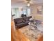 Cozy living room featuring hardwood floors, modern sofa, and decorative rug at 128 Brookhaven Ln, Mcdonough, GA 30253