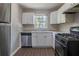 Functional kitchen with stainless steel appliances, granite countertops and bright white cabinets at 4684 City View Dr, Forest Park, GA 30297