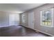 Bright living room featuring fresh paint, laminate flooring, and natural light from large windows at 4684 City View Dr, Forest Park, GA 30297