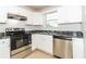 Galley style kitchen featuring stainless steel appliances, gray countertops, and white cabinets at 5880 Trent Walk Dr, Lithonia, GA 30038